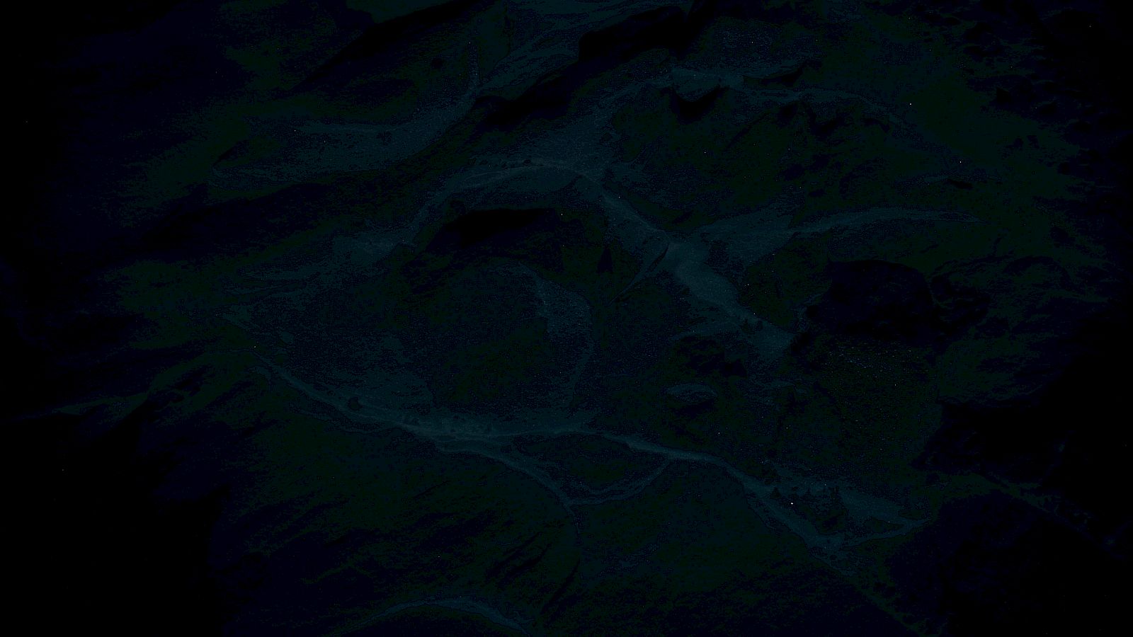 The image is very dark and details are hard to discern, but it seems to depict a natural landscape or terrain.